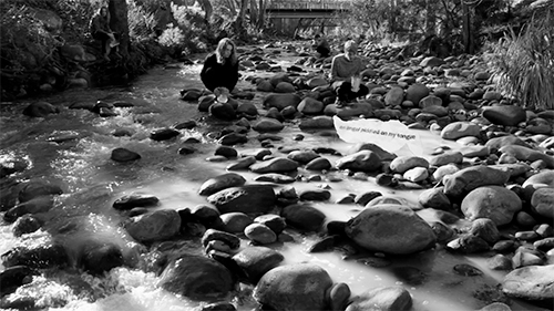People pouring jugs of milk into the river